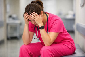 Stressed Healthcare Worker in Pink Scrubs